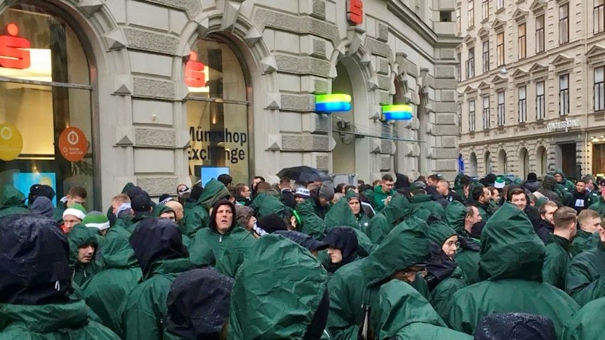 Fans von Borussia Mönchengladbach in der Innenstadt von Graz mit grünen Regenjacken.