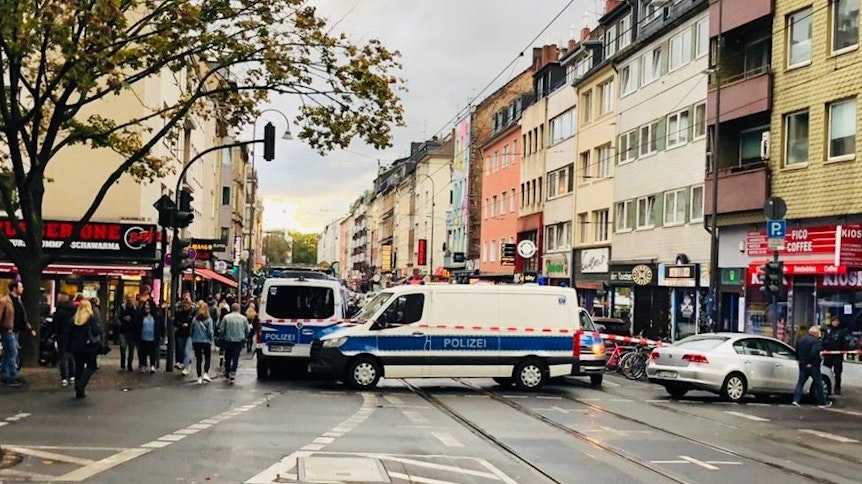 Mehrere Polizeiautos riegeln in der Stadt Köln eine Straße ab.