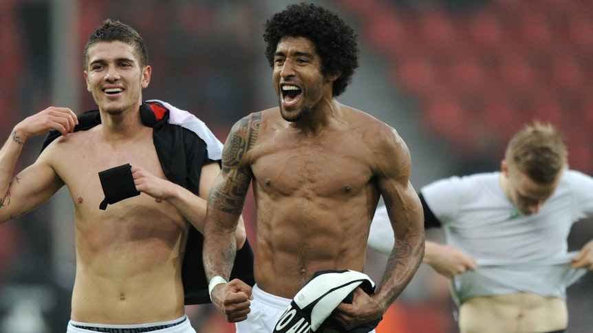 Der brasilianische Abwehrstar Dante (M.), hier gemeinsam mit Roman Neustädter (l.), im Hintergrund Oscar Wendt, zeigt im März 2012 seinen nackten Oberkörper.