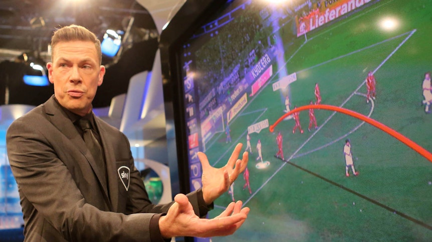 Erik Meijer analysiert vor einer Videowand eine Spielszene als Experte für den TV-Sender Sky.