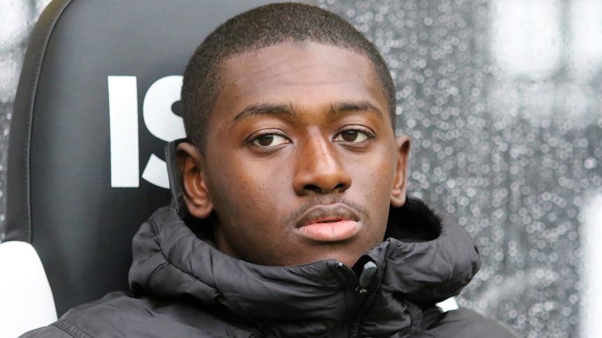 Borussias Abwehrspieler Mamadou Doucouré sitzt auf der Bank und guckt verträumt.
