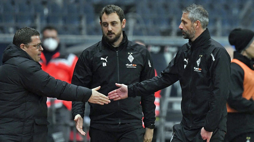 Mönchengladbachs Sportdirektor Max Eberl (l.) gratuliert Trainer Marco Rose (r.) nach dem 3:3-Unentschieden bei Eintracht Frankfurt. In der Mitte zu sehen ist Borussias Co-Trainer René Marić.