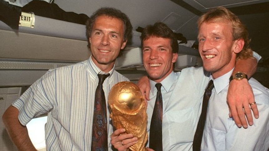 Franz Beckenbauer, Lothar Matthäus (Mitte) und Andreas Brehme zeigen 1990 stolz den gewonnenen WM-Pokal.