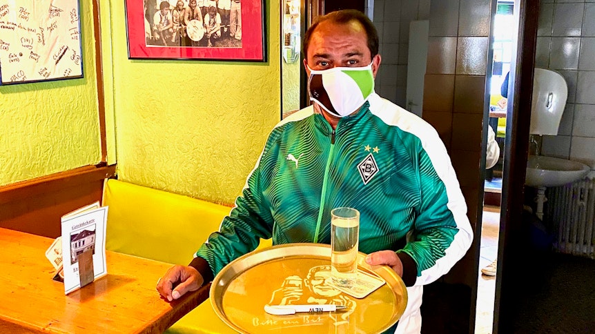 Alles nach Vorschrift: Mit Borussia-Mundschutz bedient Kult-Wirt Mustafa Cetin am Samstag, wenn die Fohlen in Frankfurt zum Geisterspiel antreten, seine Gäste.