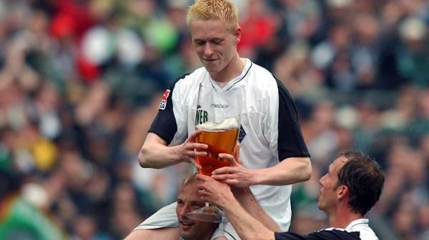 Borussen 2003 unter sich: Stürmer Arie van Lent (unten) trägt auf seinen Schultern Team-Kollege Mikael Forssell, der von Jeff Strasser (r.) ein Bierglas gereicht bekommt.