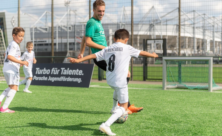 Gladbach-Profi Patrick Herrmann im Übungsspielchen mit einigen Nachwuchs-Talenten auf dem Trainingsgelände im Borussia-Park. Im Hintergrund ist der Borussia-Park zu sehen.