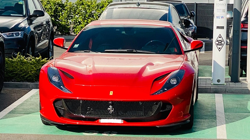 Ein roter Ferrari steht auf einem Parkplatz im Gladbacher Borussia-Park.