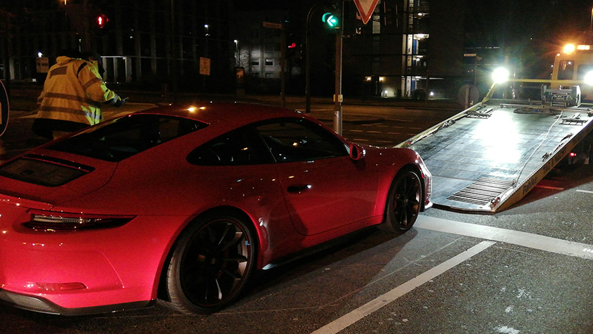 Ein Abschlepper hat einen roten Porsche am Haken.