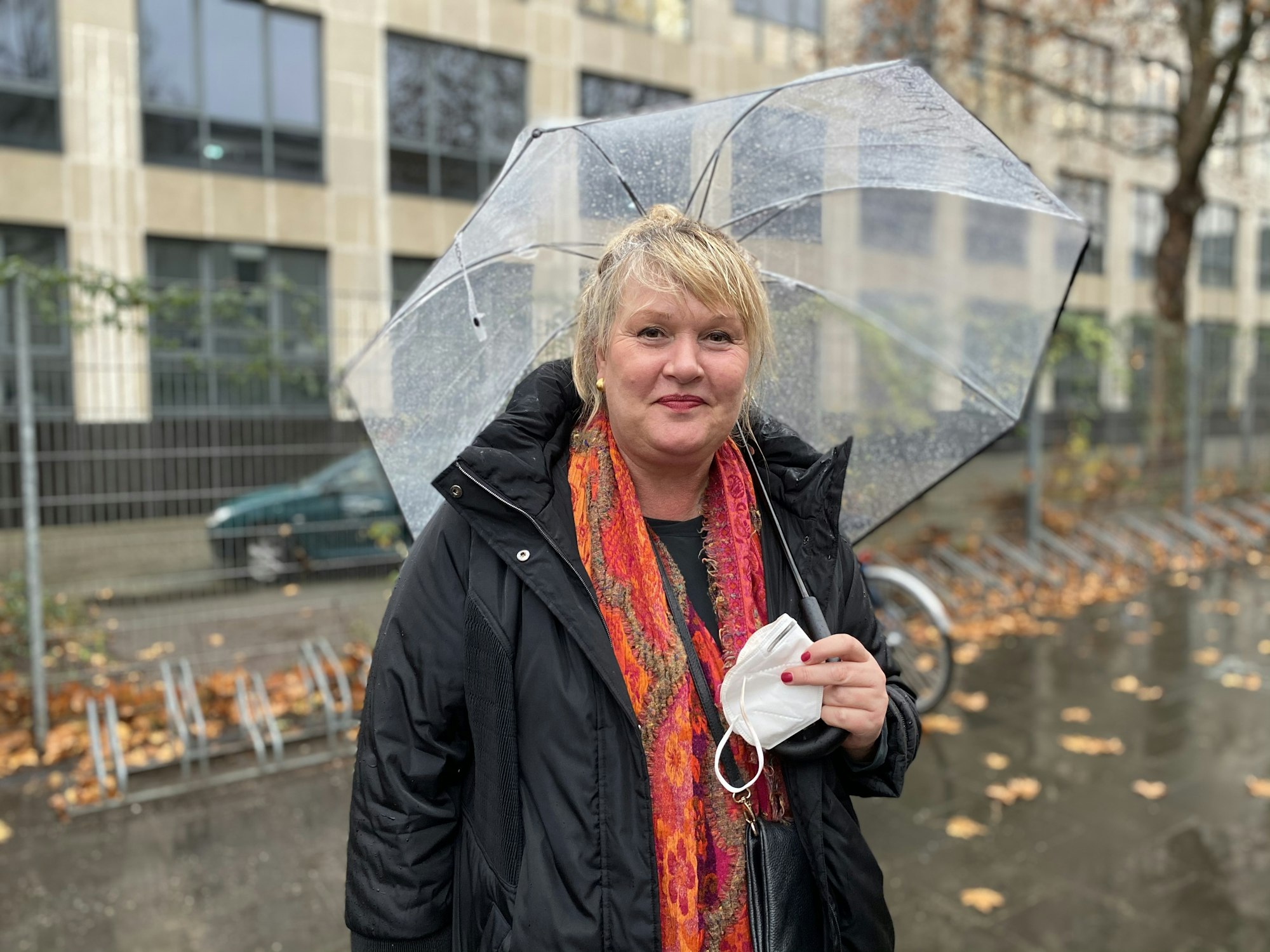 Stadt-Mitarbeiterin Claudia während eines Drehs mit einem Regenschirm.