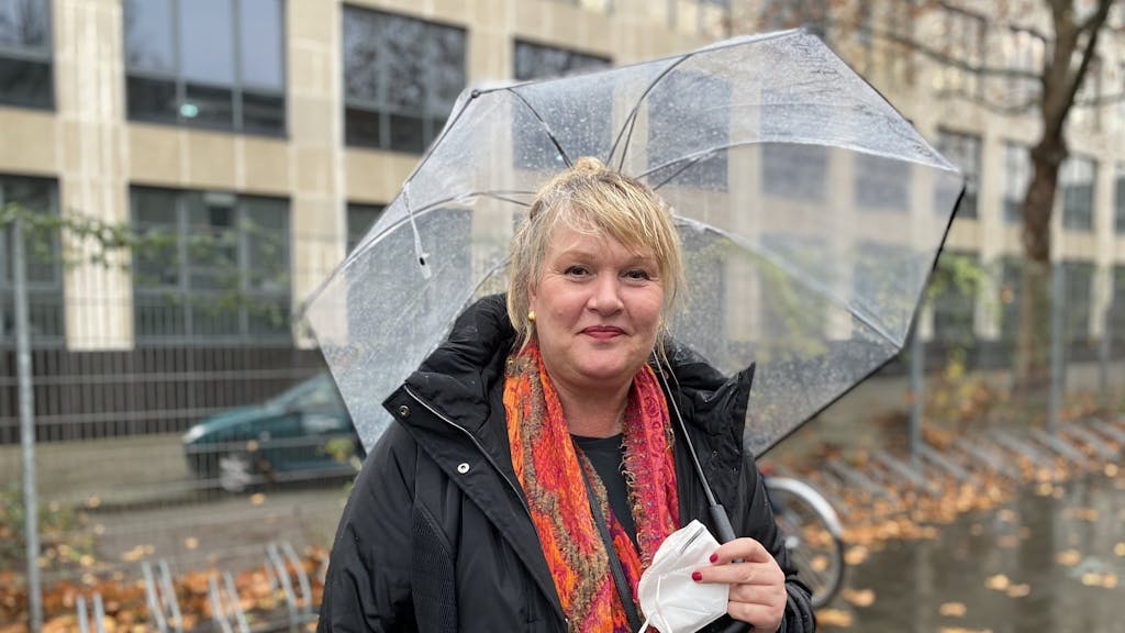 Stadt-Mitarbeiterin Claudia während eines Drehs mit einem Regenschirm.