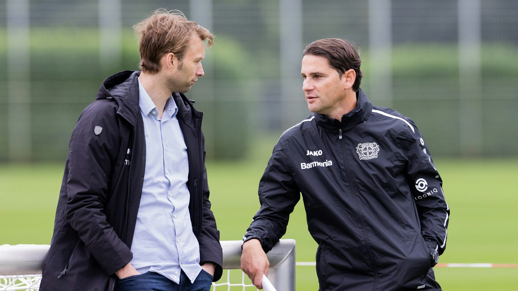 Gerardo Seoane und Sportchef Simon Rolfes sprechen auf dem Trainingsplatz von Bayer Leverkusen miteinander.