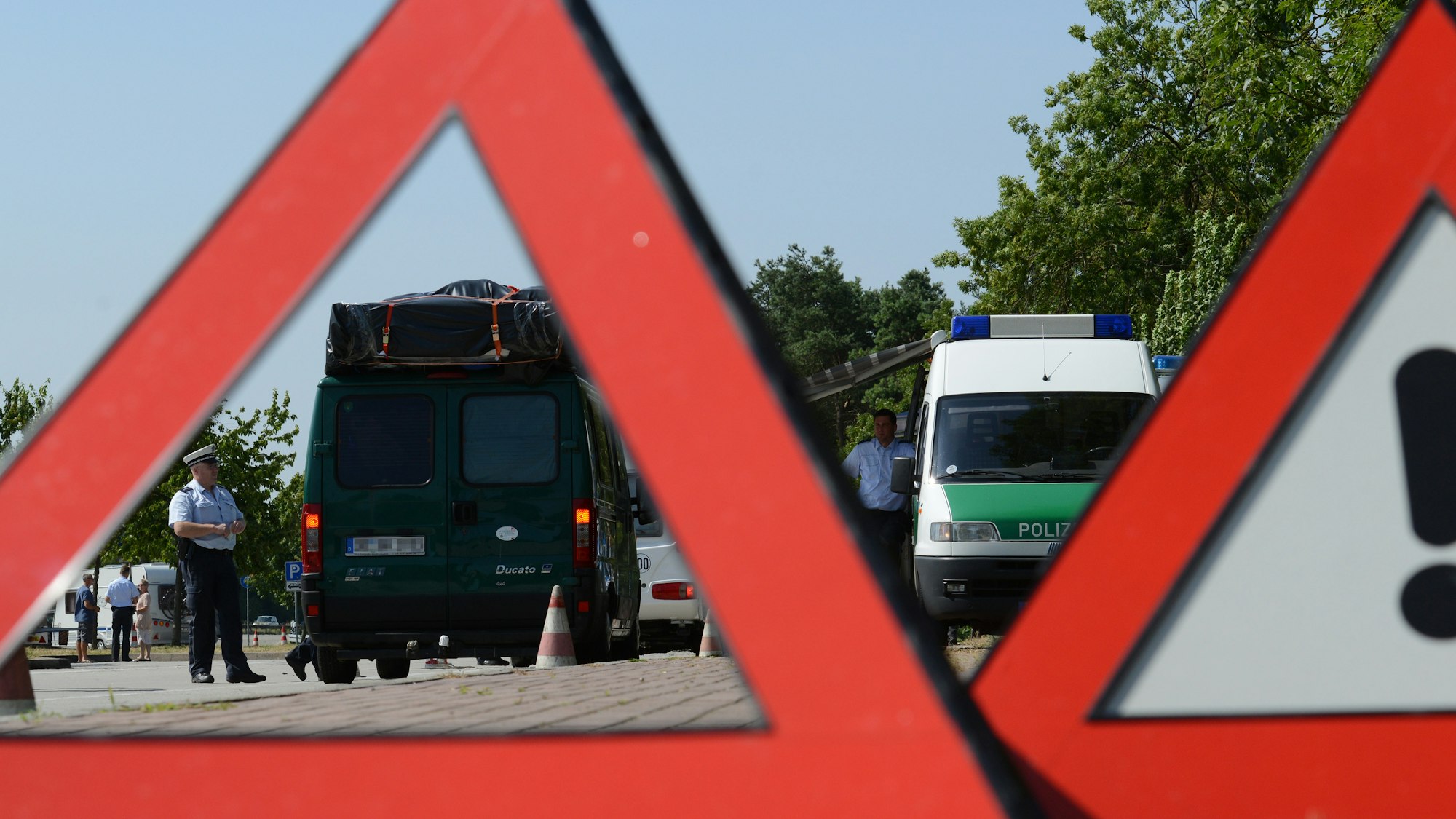 Zwei Polizeibeamte kontrollieren am 15.07.2013 an der A5 bei Neuenburg (Baden-Württemberg) das Gewicht eines Reisemobils.