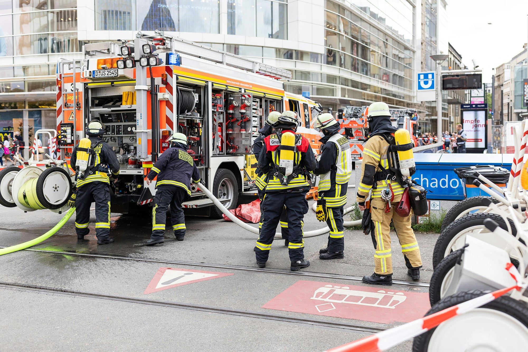 Einsatzkräfte der Feuerwehr stehen vor dem U-Bahnhof Schadowstraße.