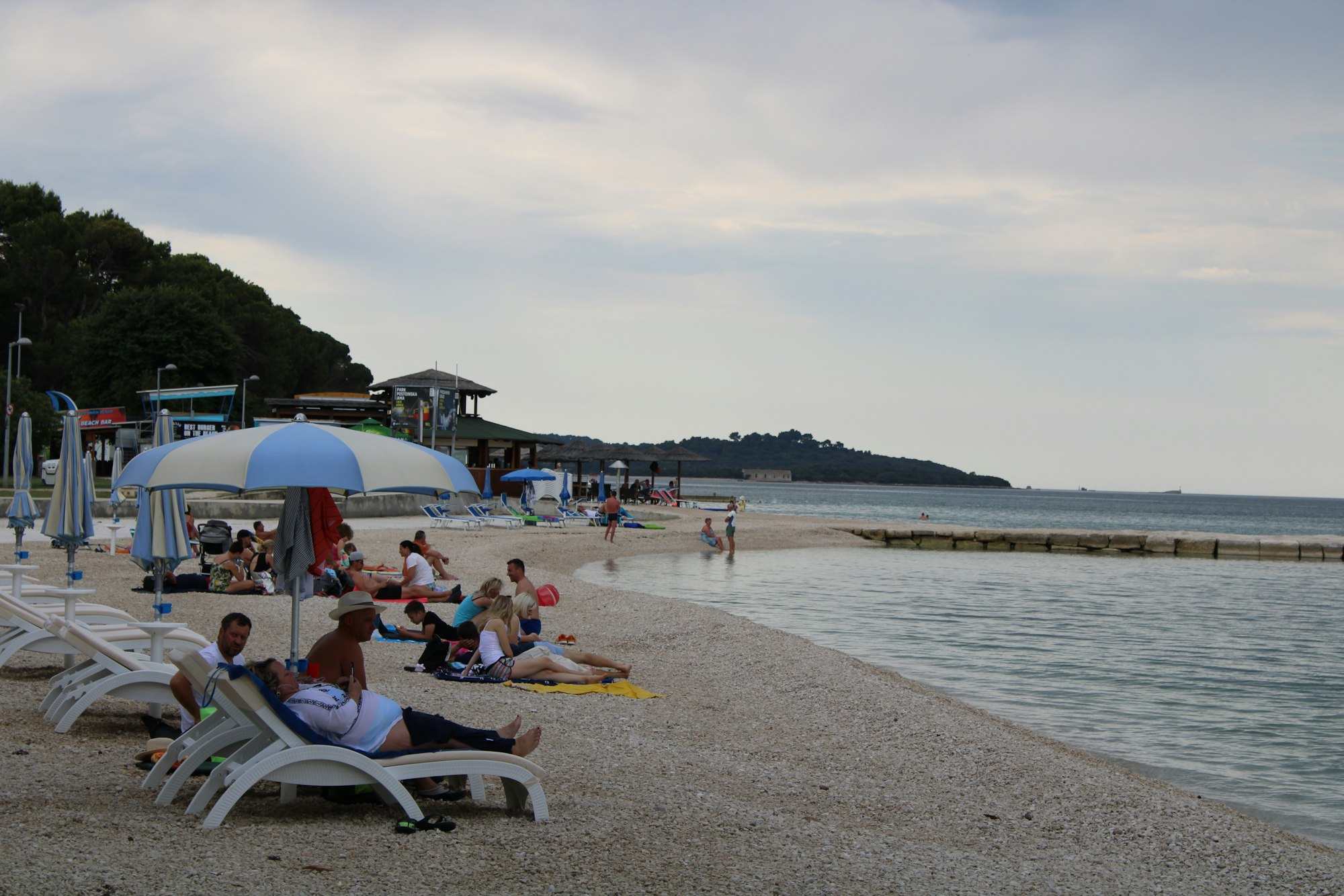 Urlauber lieben am Strand von Fazana auf der kroatischen Halbinsel Istrien.