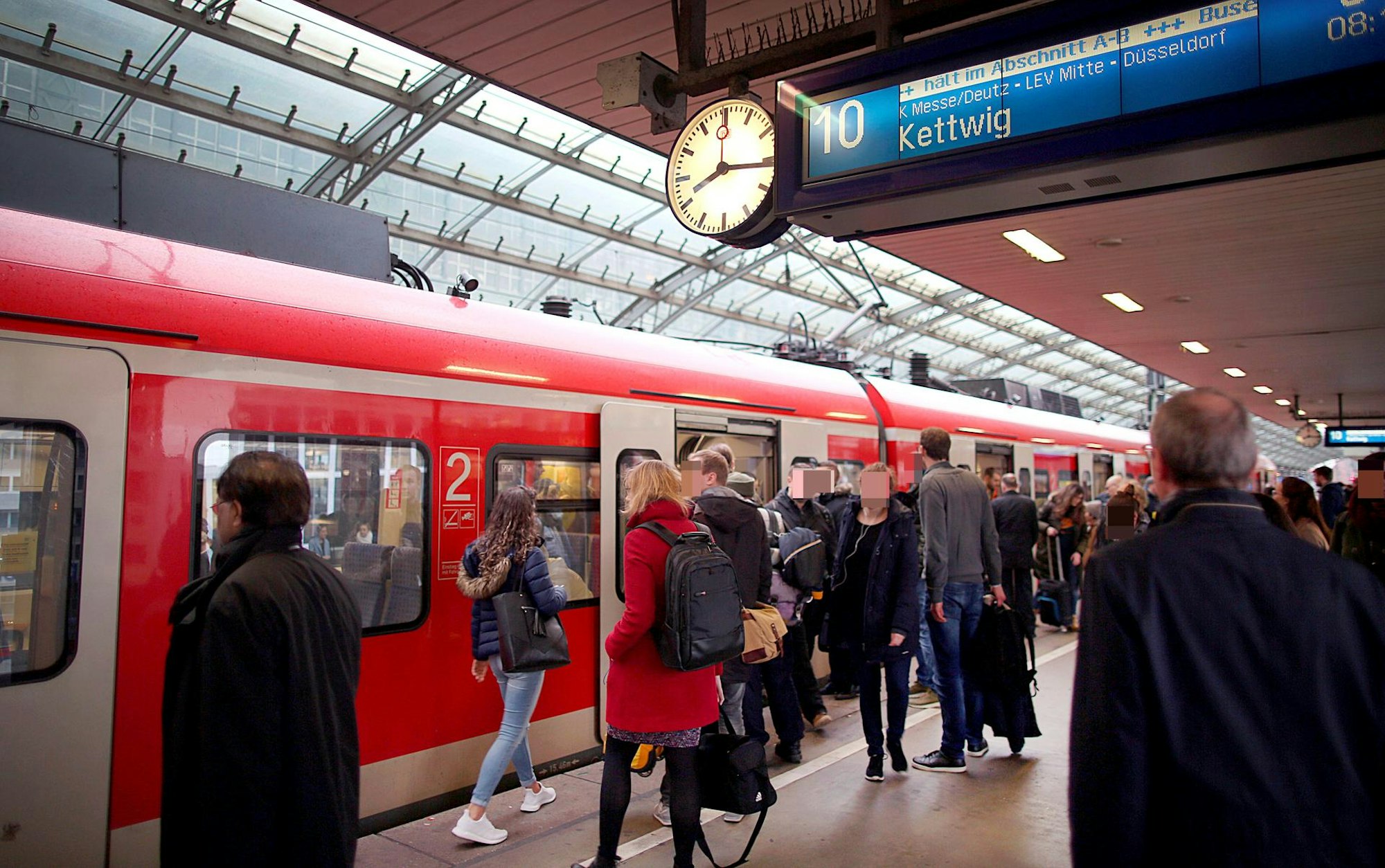 Fahrgäste an einem Zug im Kölner Hauptbahnhof.