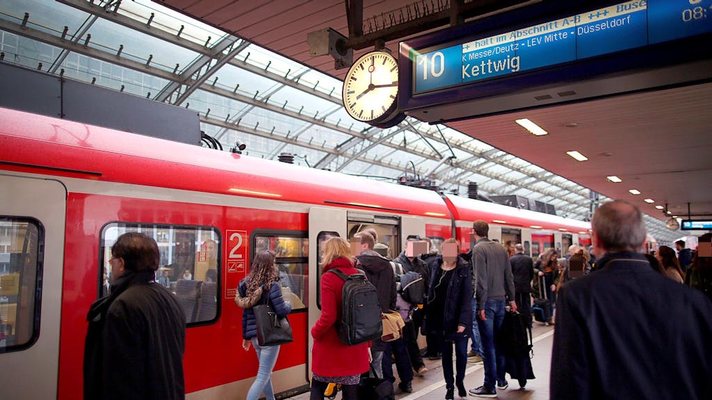 Fahrgäste an einem Zug im Kölner Hauptbahnhof.