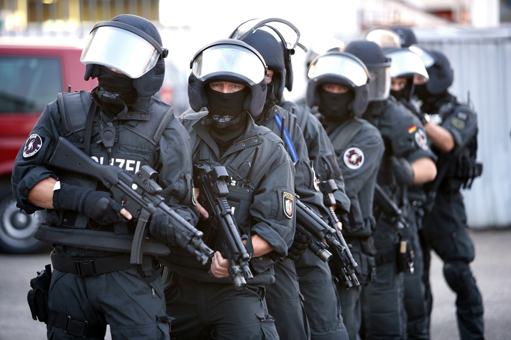 Zehn SEK-Beamte stehen mit Helmen, Westen und Waffen hintereinander.
