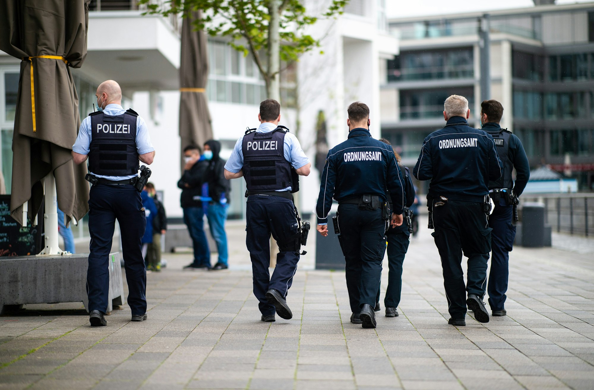 Sechs Mitarbeiter des Ordnungsamtes und Polizisten gehen an der Promenade am Phönixsee entlang.