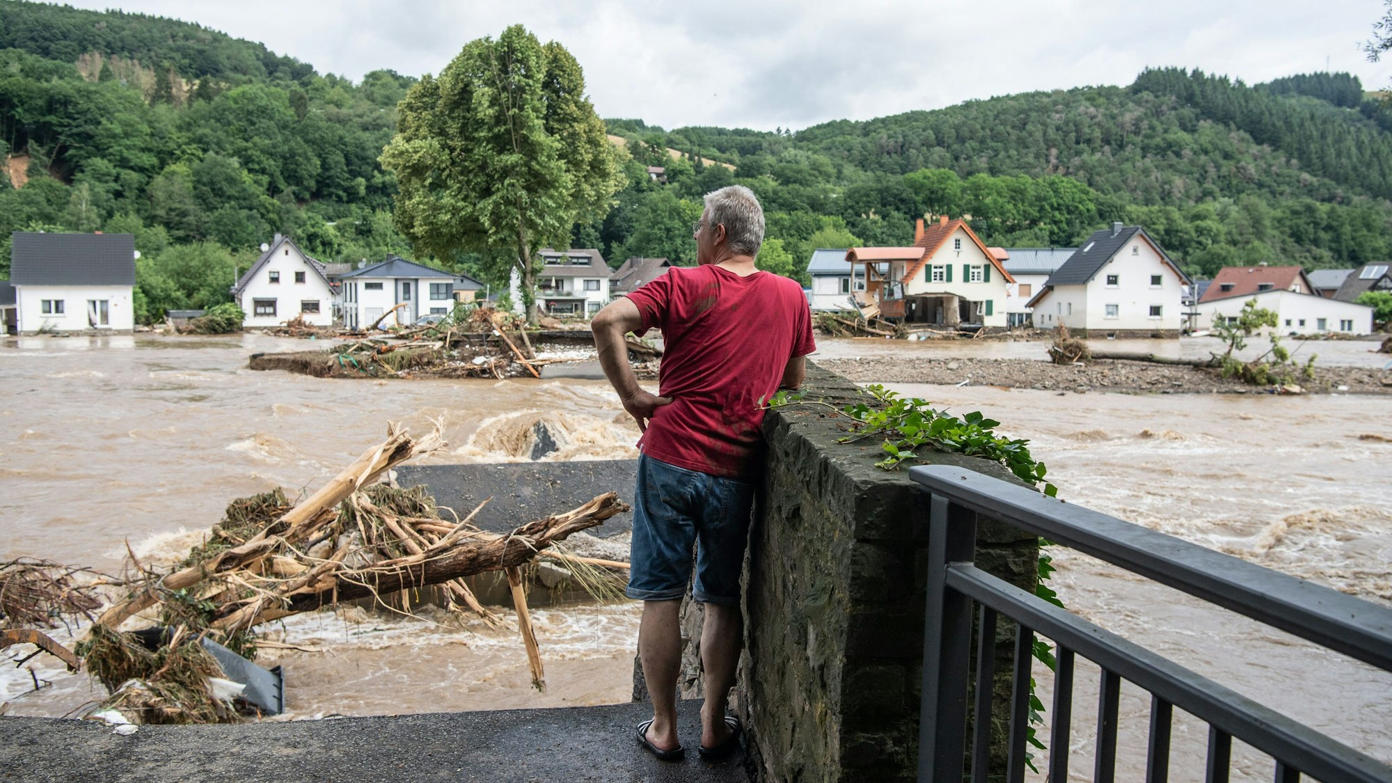 Ein Mann blickt in Insul (Rheinland-Pfalz) zu seinem Elternhaus auf der anderen Flussseite hinüber.