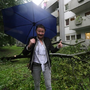 Die Kölnerin Sabina Meyer-Molnar steht neben einem Baum, der drohte, auf ihr Haus zu stürzen.