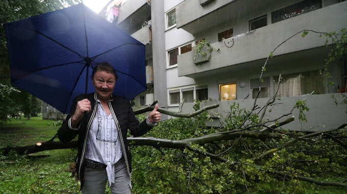 Die Kölnerin Sabina Meyer-Molnar steht neben einem Baum, der drohte, auf ihr Haus zu stürzen.