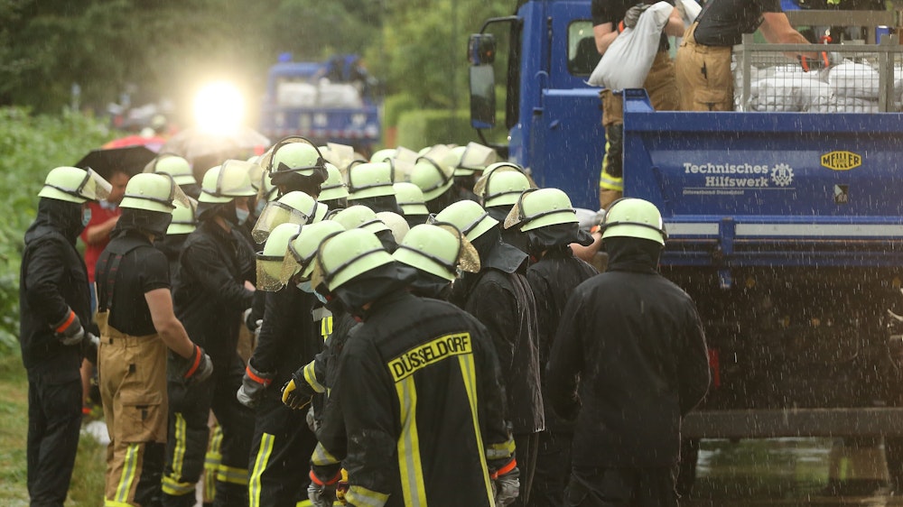 Düsseldorf: Feuerwehrleute arbeiten in der Ostparksiedlung. Die Feuerwehr versucht, die Wassermassen mit Sandsäcke zu stoppen.
