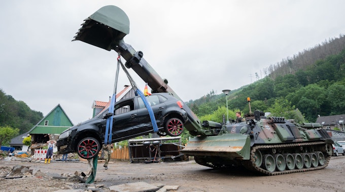 Soldaten der Bundeswehr bergen mit einem Pionierpanzer Dachs ein zerstörtes Auto bei den Aufräumarbeiten der schweren Unwetterschäden im Ortsteil Hohenlimburg bei Hagen.