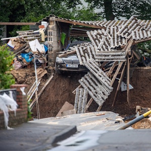 Ein Auto hängt im Ortsteil Blessem über einem Abgrund. Starkregen hatte am Mittwoch (14. Juli 2021) zu schweren Überschwemmungen und Hochwasser geführt.