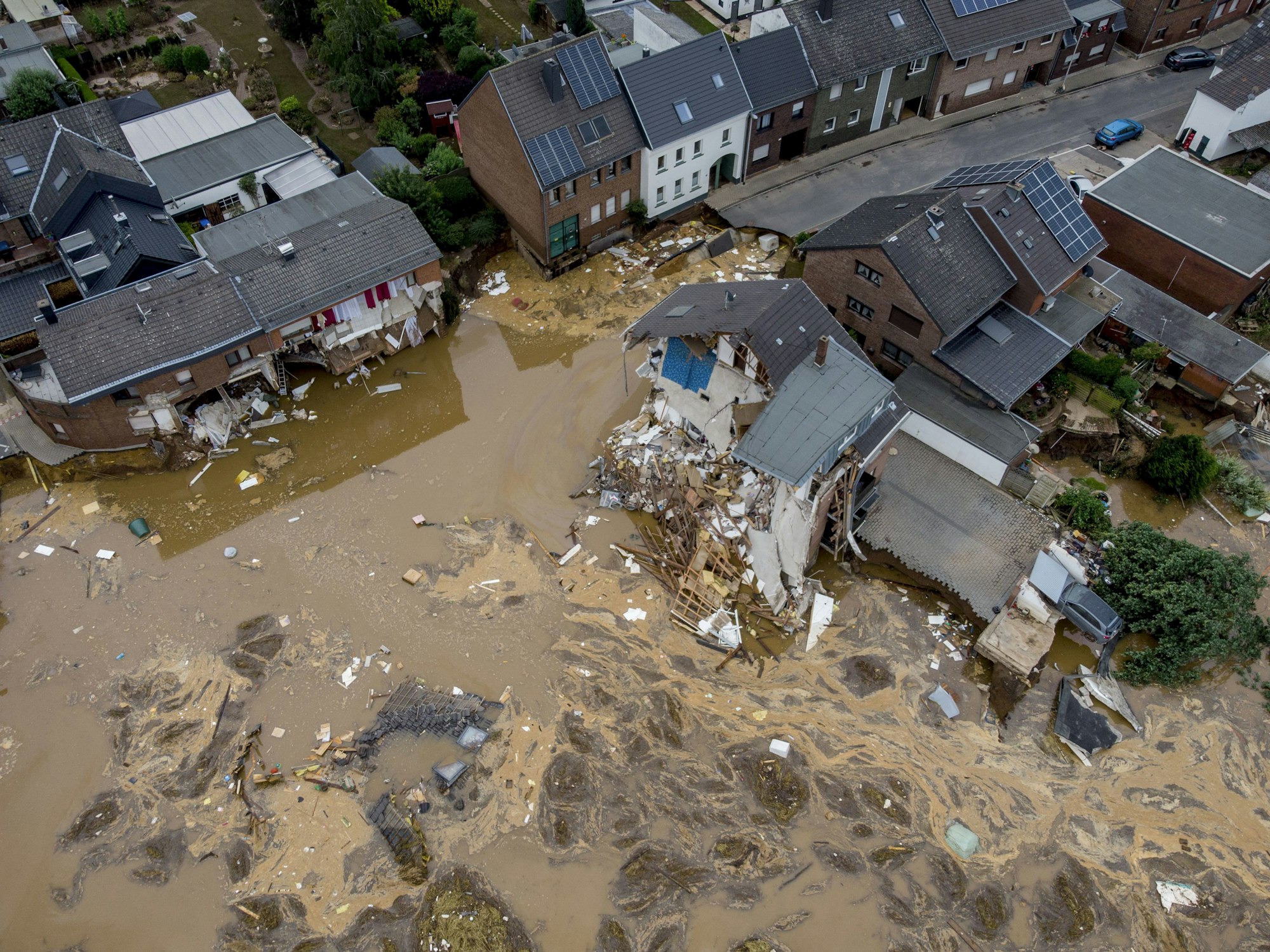 Luftaufnahme zerstörter Häuser in Erftstadt nach Flut-Katastrophe. In den Straßen befinden sich noch Wasser, Schlamm und Geröll.