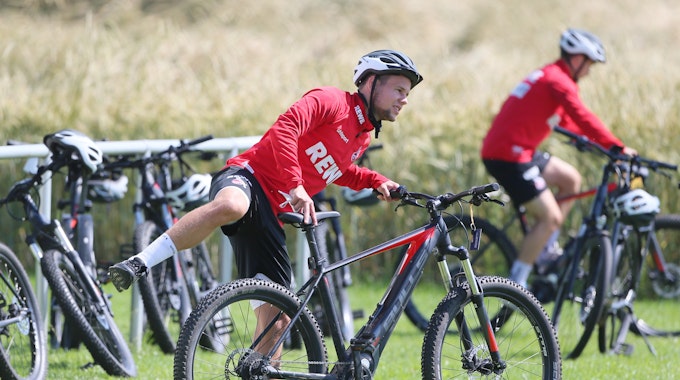 Louis Schaub steigt im Trainingslager des 1. FC Köln aufs Fahrrad.