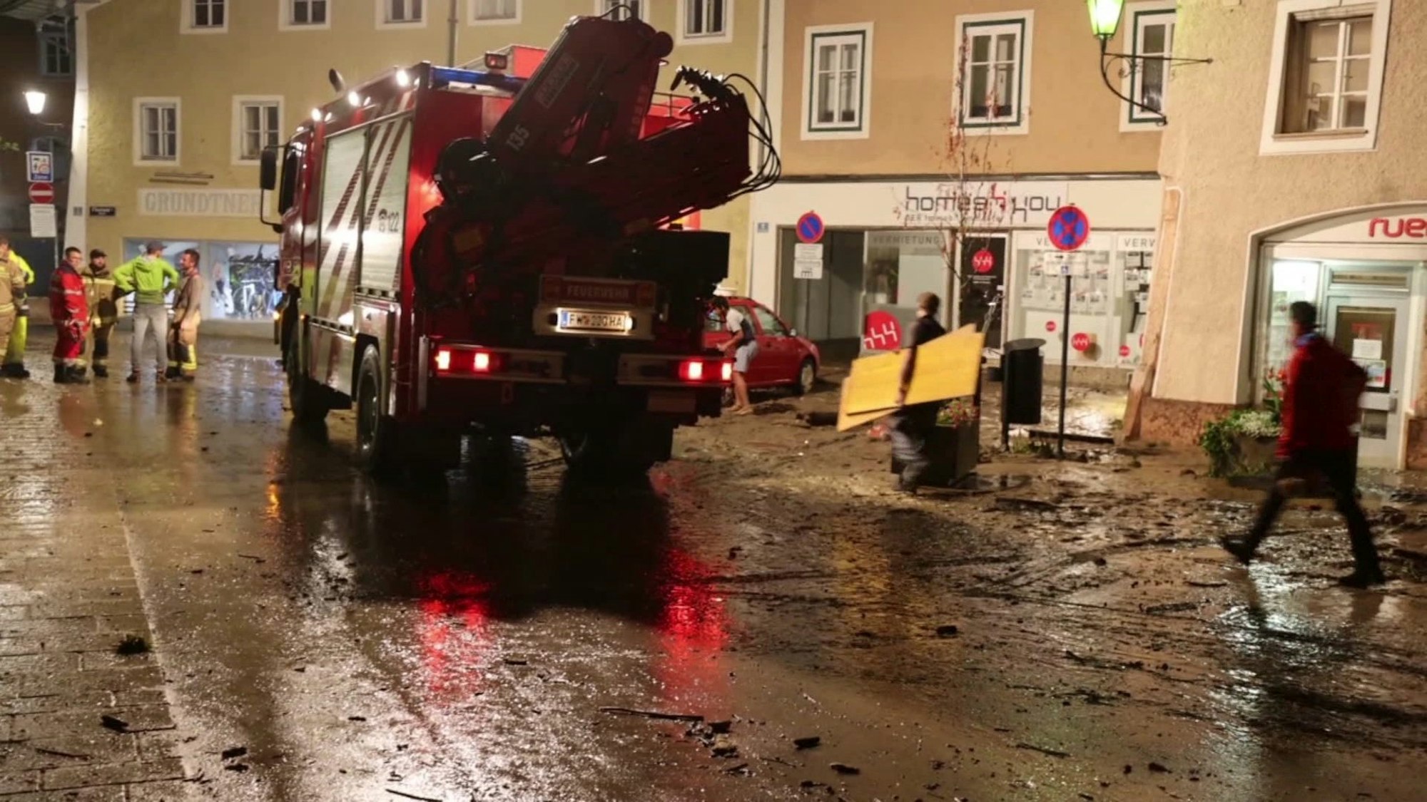 Unwetter Österreich:Nächtliche Aufräumarbeiten auf einer vom Hochwasser betroffenen Straße in der Altstadt von Hallein bei Salzburg.