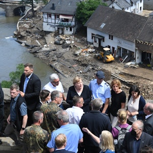 Bundeskanzlerin Angela Merkel (3.v.l.) und die rheinland-pfälzische Ministerpräsidentin Malu Dreyer (5.v.l.,SPD) stehen während ihres Besuchs in den vom Hochwasser betroffenen Gebieten auf einer Brücke.
