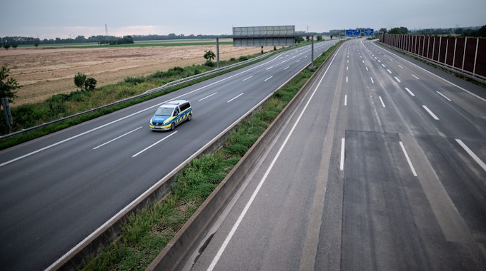 Die gesperrte Autobahn A1 am 16. Juli 2021 bei Blessem in Erftstadt. Ein Polizeiwagen kontrolliert die Strecke.
