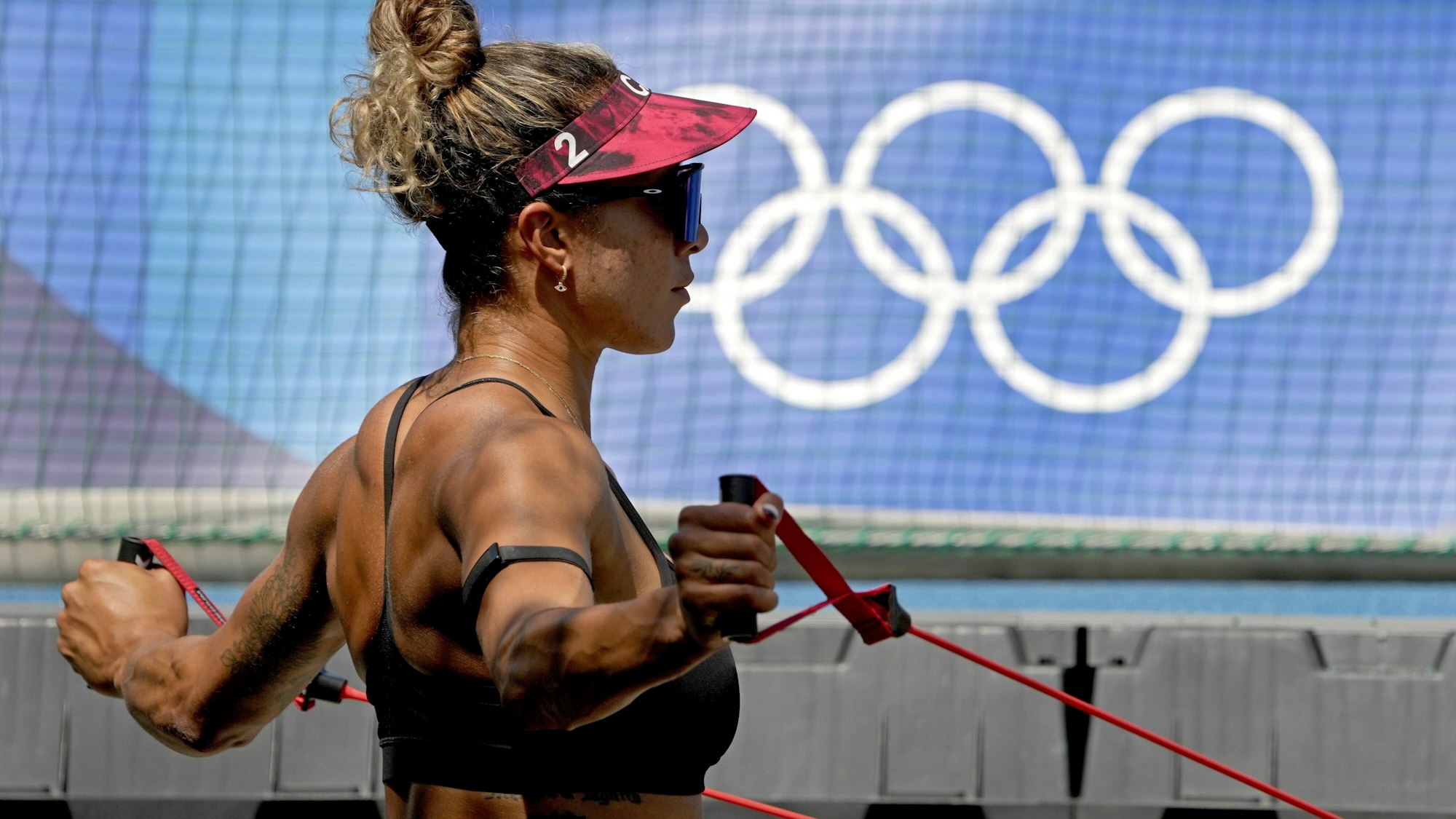 19.07.2021, Japan, Tokio: Brandie Wilkerson aus Kanada dehnt sich vor dem Training der Beachvolleyballerinnen bei den Olympischen Sommerspielen 2020. Foto: Charlie Riedel/AP/dpa +++ dpa-Bildfunk +++