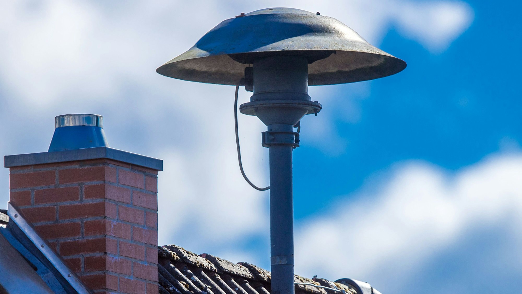 Eine Alarmsirene steht auf einem Hausdach in Lassahn in Mecklenburg-Vorpommern.