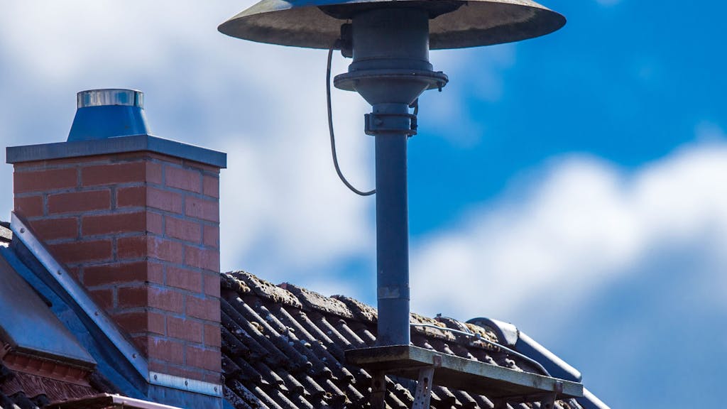 Eine Alarmsirene steht auf einem Hausdach in Lassahn in Mecklenburg-Vorpommern.