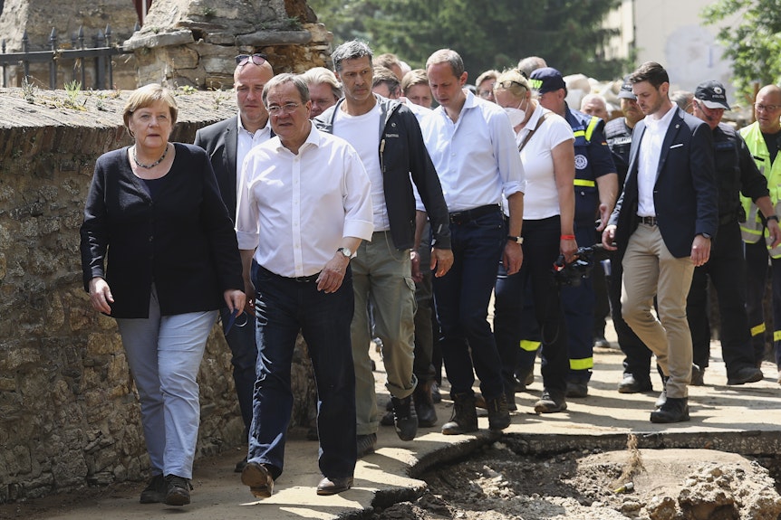 Bundeskanzlerin Angela Merkel (CDU, vorn links) und Armin Laschet (CDU, vorn rechts), Ministerpräsident von Nordrhein-Westfalen, laufen durch dich zerstörten Straßen von Bad Münstereifel.