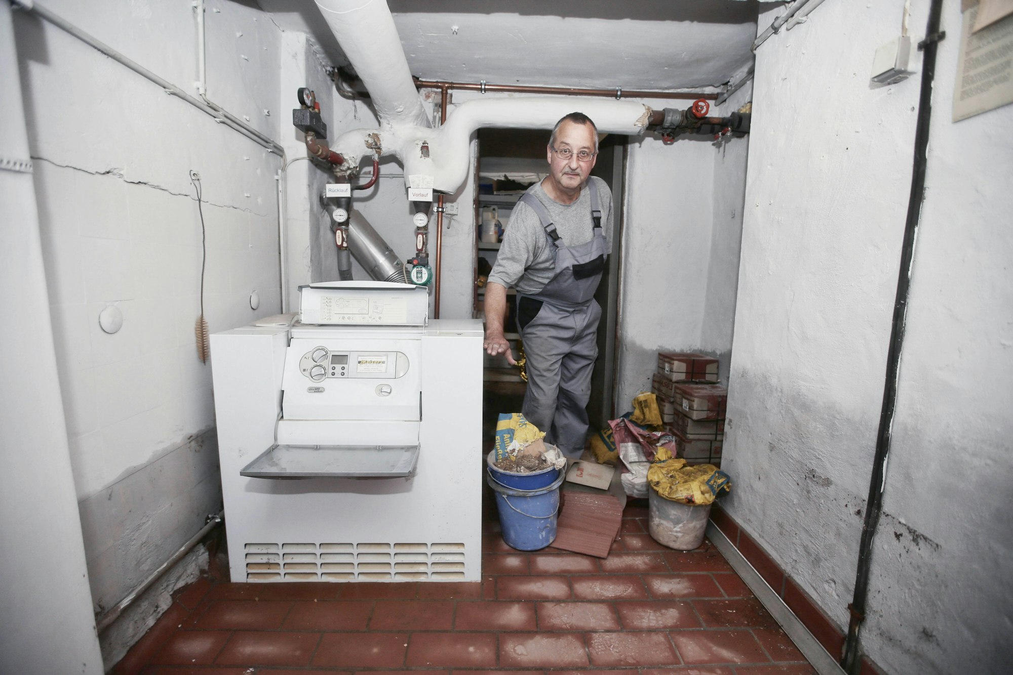 Schornsteinfeger Wolfgang Neuhaus zeigt die bis oben zugelaufene Heizung des Vereinsheims im Keller.