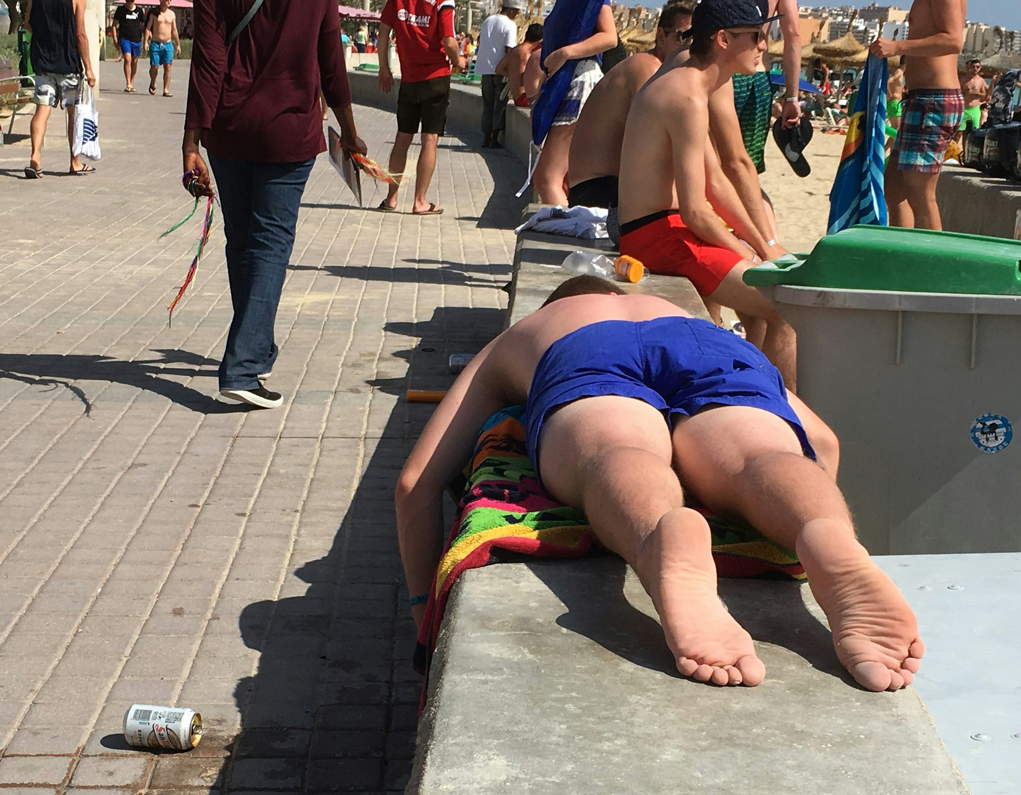 Ein Mann liegt am 30.06.2016 in Palma de Mallocra (Spanien) am Playa de Palma neben einer umgekoippten Bierdose und einem Abfalleimer auf einer Mauer. Symbolbild für einen Mann, der am Ballermann auf Mallorca totgeprügelt worden ist