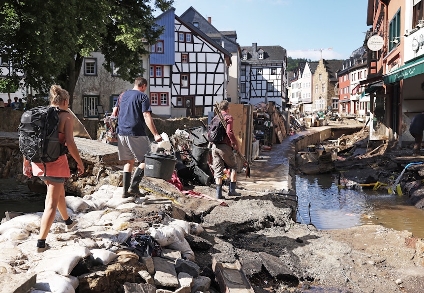 Helfer gehen durch den Ortskern. In Bad Münstereifel hat die über die Ufer getretene Erft erhebliche Schäden angerichtet.