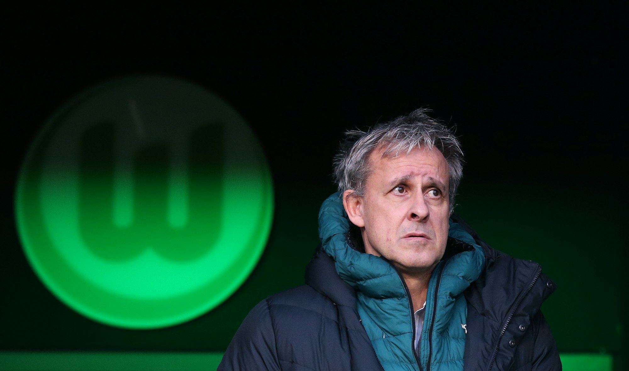 Pierre Littbarski vor dem Logo des VfL Wolfsburg
