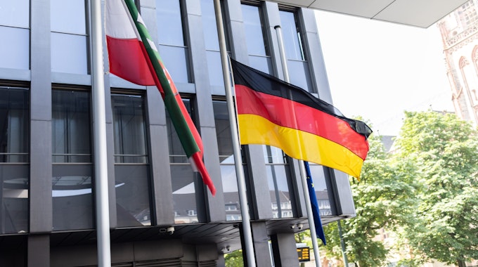 Am 17. Juli 2021 wehen vor einem Gebäude in Düsseldorf die Flaggen von Nordrhein-Westfalen, Deutschland und der EU auf Halbmast.
