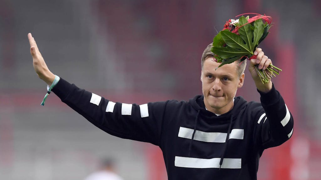 Felix Kroos mit einem Blumenstrauß in der Hand