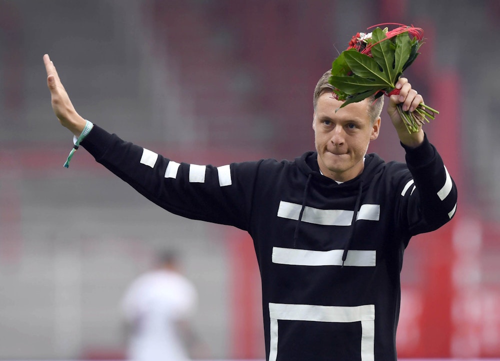 Felix Kroos mit einem Blumenstrauß in der Hand