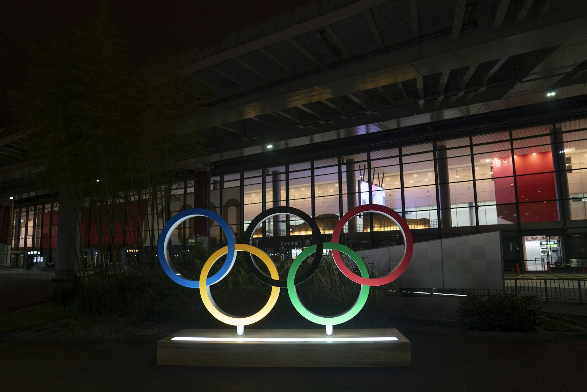 Die Olympischen Ringe werden im Dunkel vor dem Narita International Airport angeleuchtet.