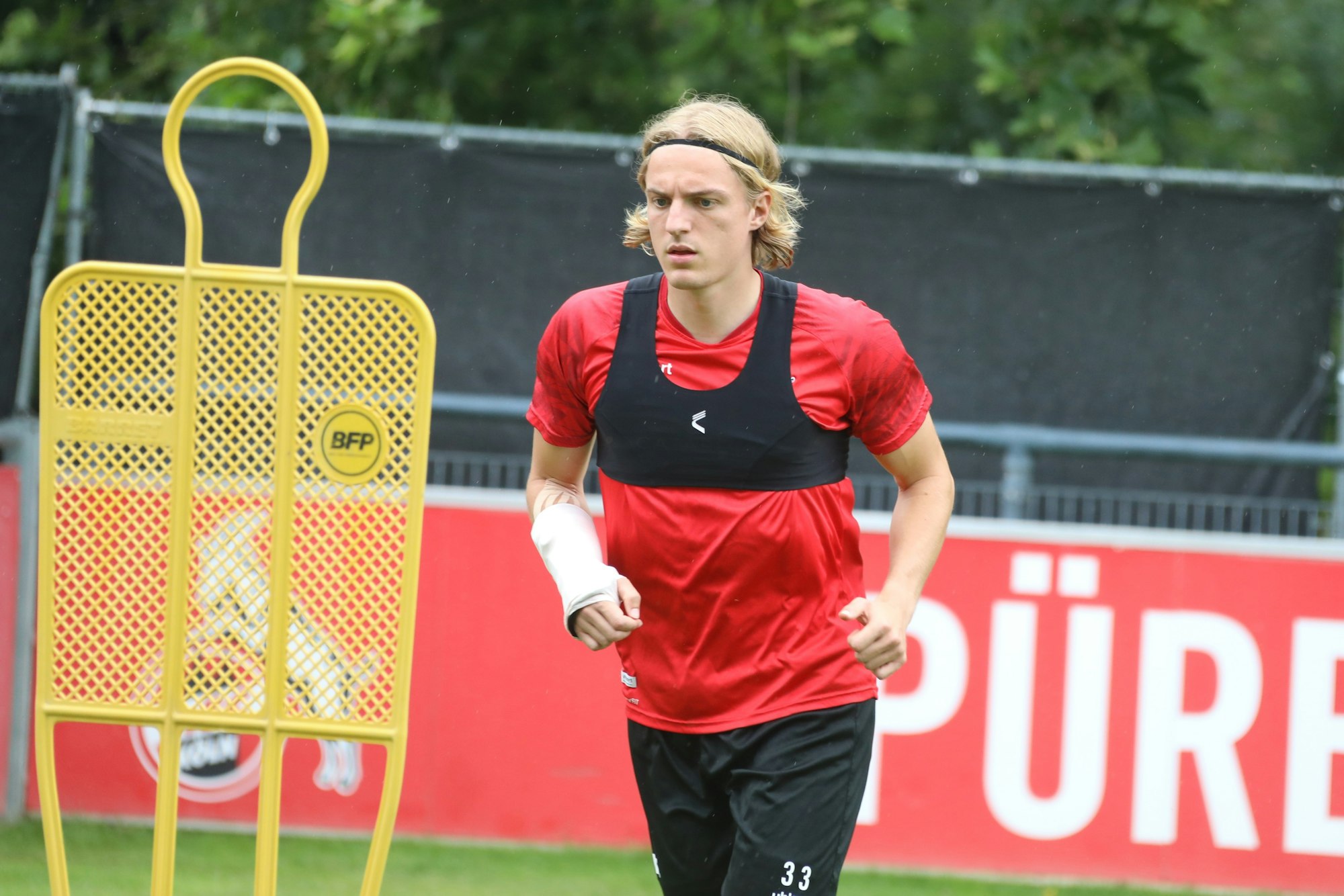Sebastiaan Bornauw trainiert beim 1. FC Köln mit Handmanschette.
