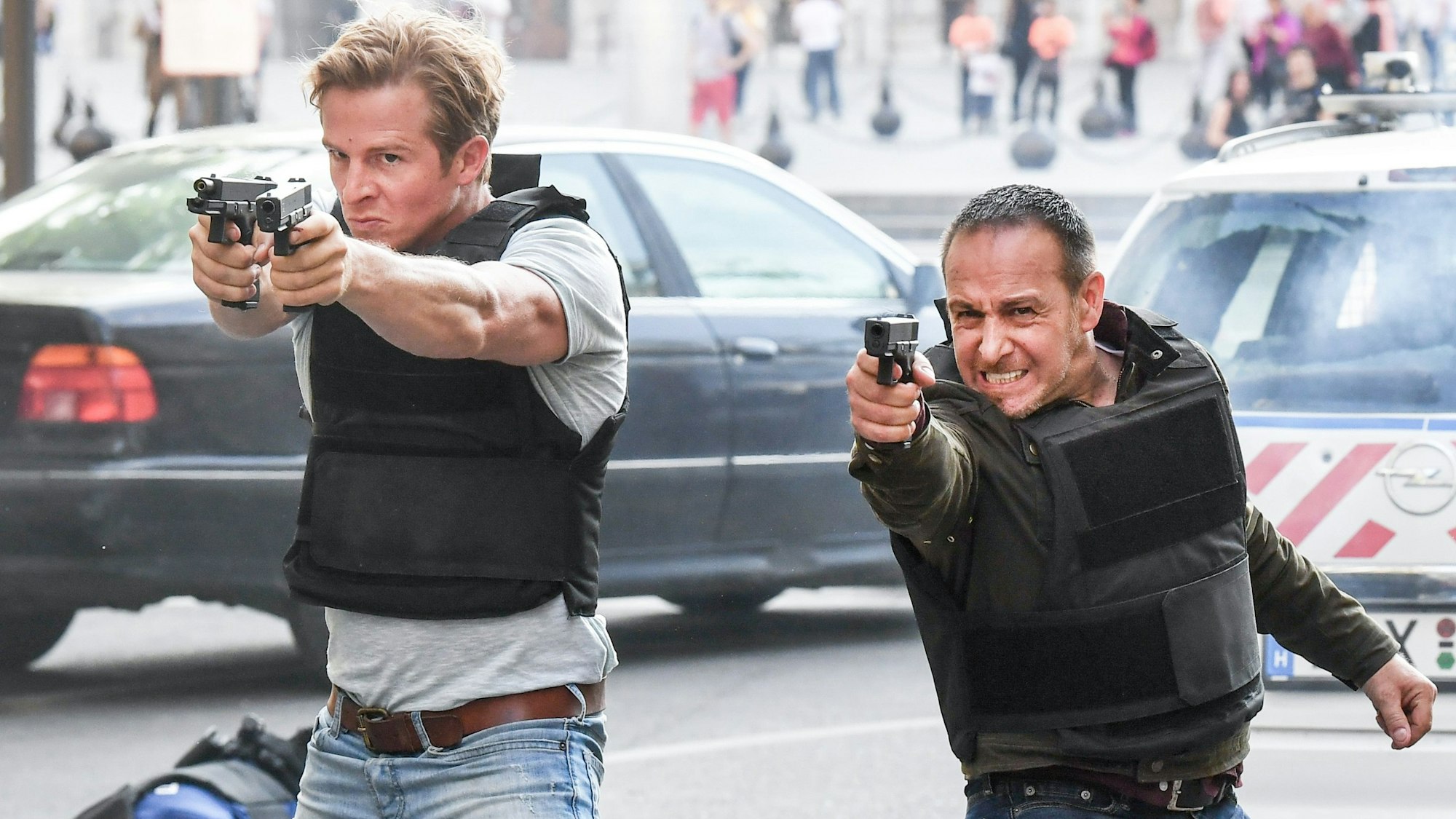 Erdogan Atalay und Daniel Roesner stehen mit gezückten Pistolen in den Händen bei einer Schießszene der RTL-Action-Serie ´Alarm für Cobra 11 - Die Autobahnpolizei” im Set.