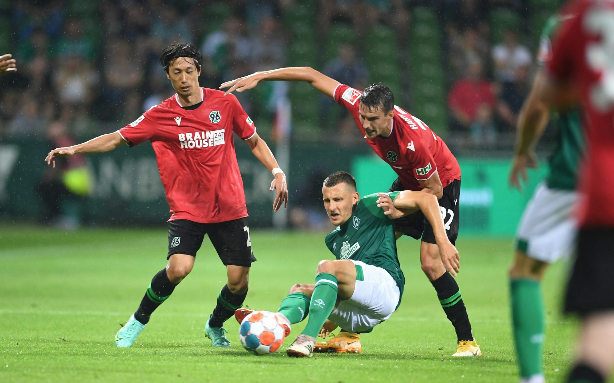 Werder Bremens Maximilian Eggestein im Duell mit Sei Muroya und Sebastian Stolze von Hannover 96