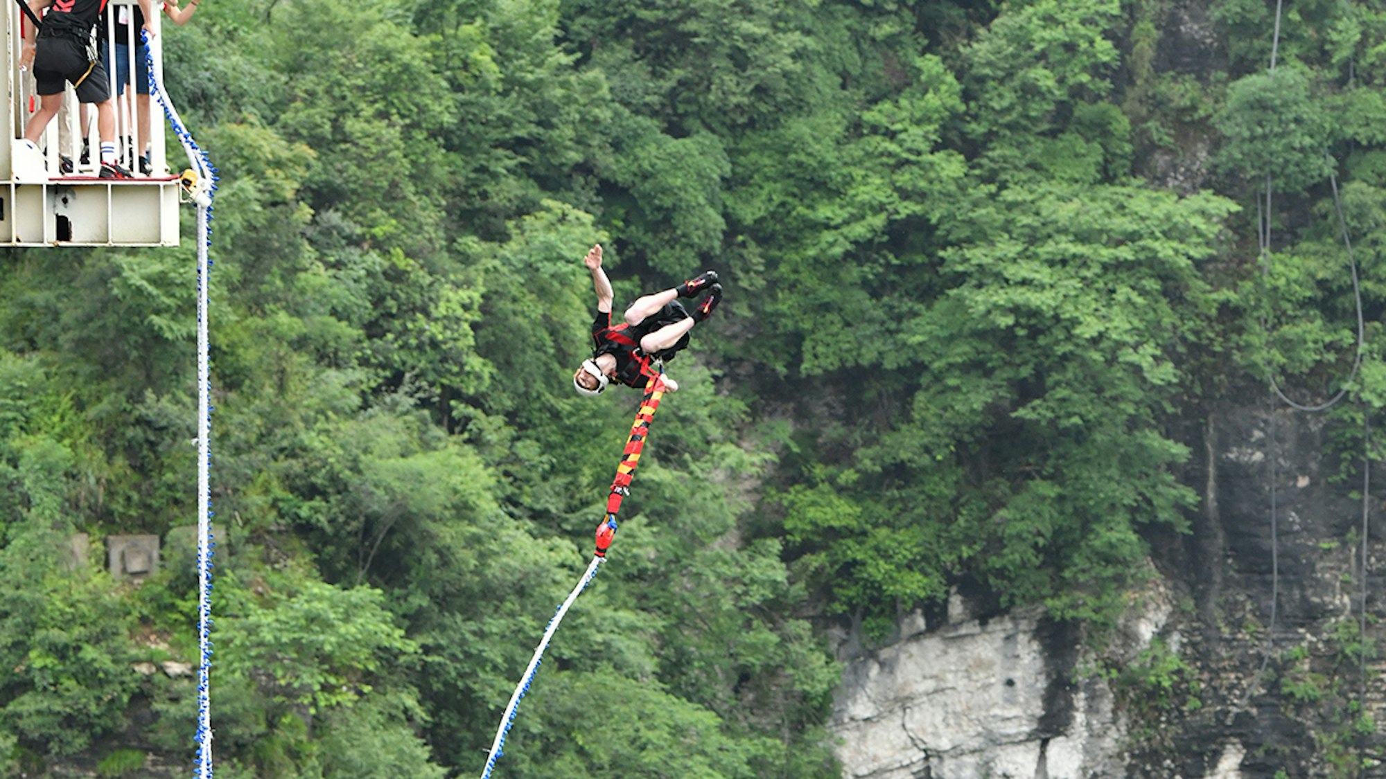 Ein Bungeespringer springt von der Glasbrücke Zhangjiajie in China.