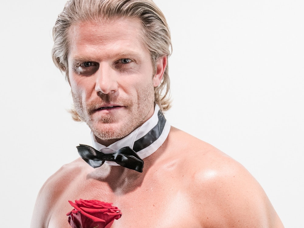 Ex-Bachelor Paul Janke mit nacktem Oberkörper, einer Fliege um den Hals und einer Rose in der Hand.